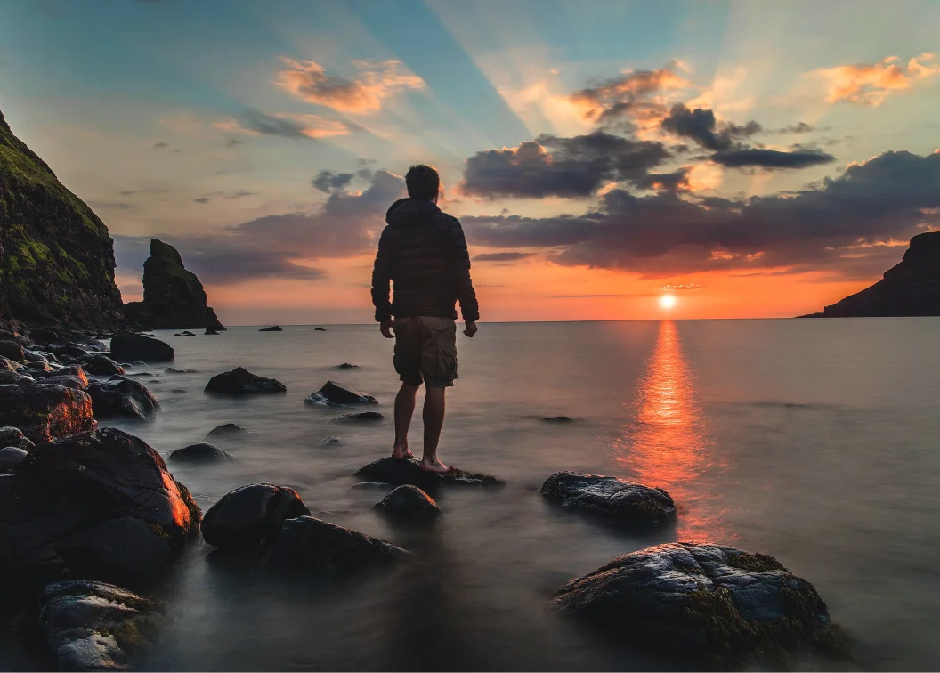 Man standing up and watching Madeira sunset.